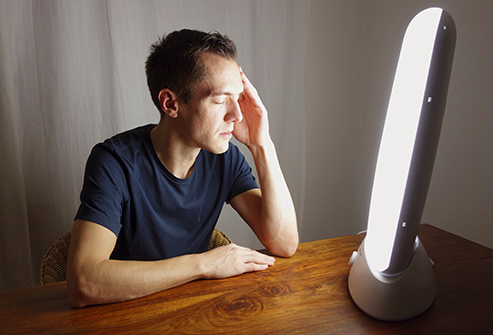 493_getty_rf_man_sitting_by_light_box